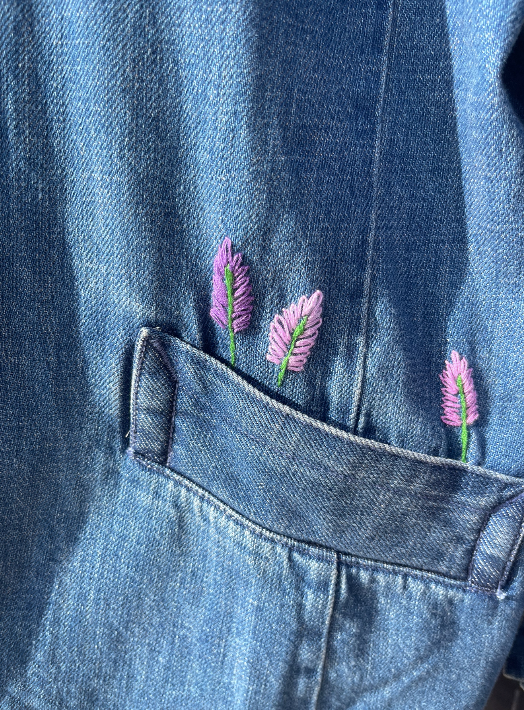 Detalle de flores bordadas a mano en chamarra de mezclilla para mascota